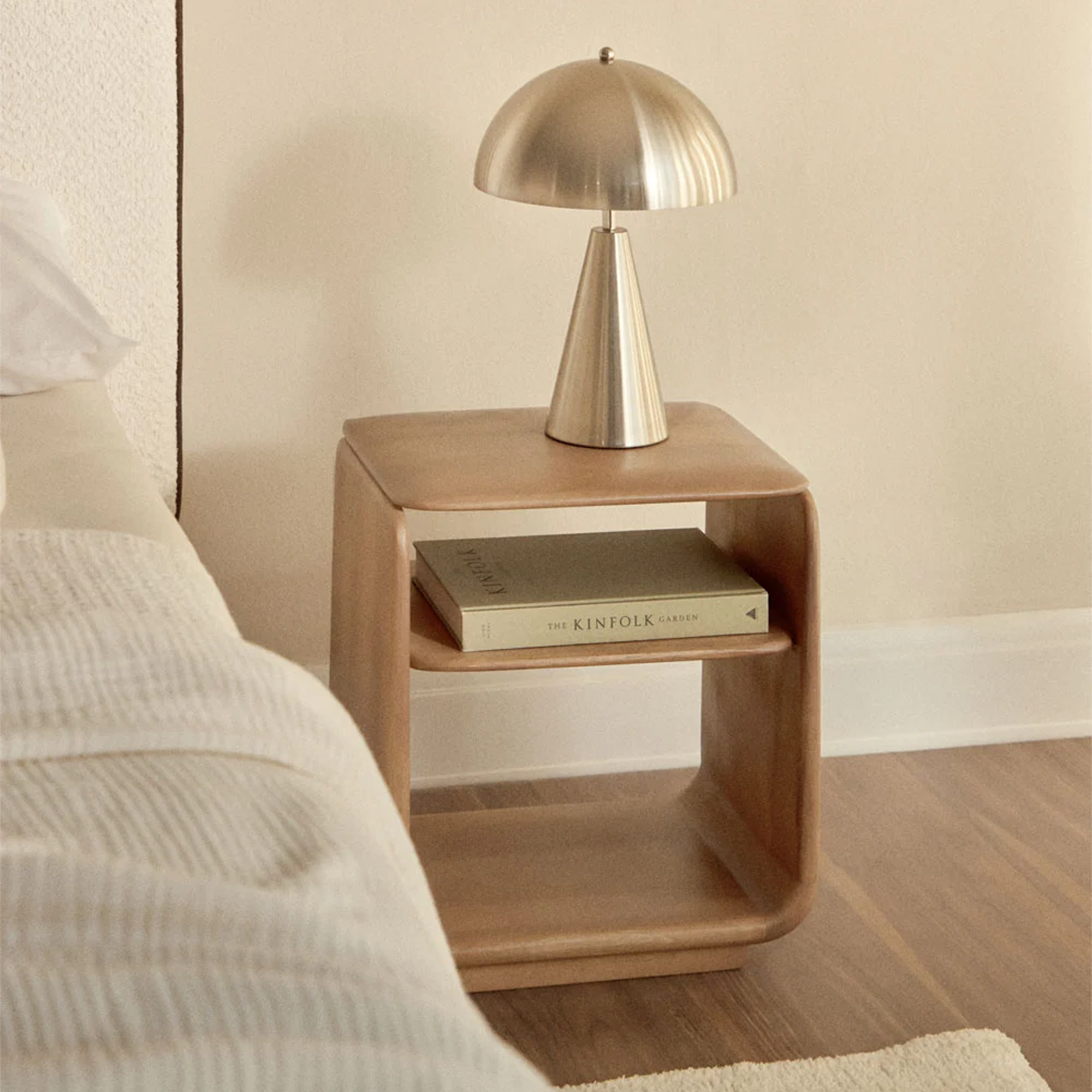 Naktinis staliukas pagamintas iš medienos šalia lovos Japandi interjere